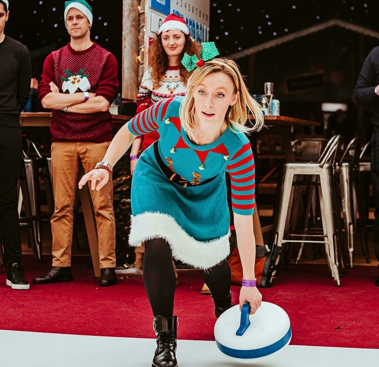 Woman curling wearing Xmas elf outfit